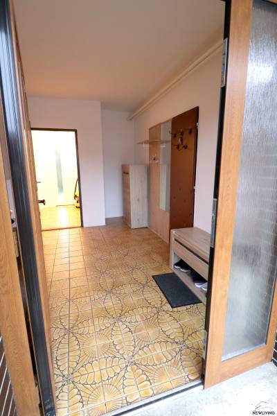 Entrance hall in a family house with tiles in soft shades and wooden furniture.