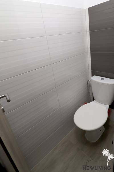 Bathroom in a family house with modern tiles and simple toilet design.