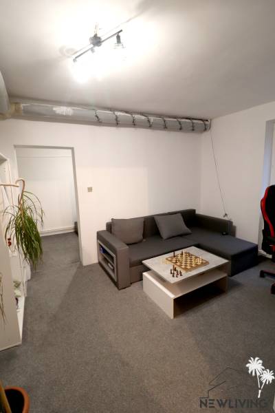 Living room with a sofa, chessboard, and carpet in a family house.