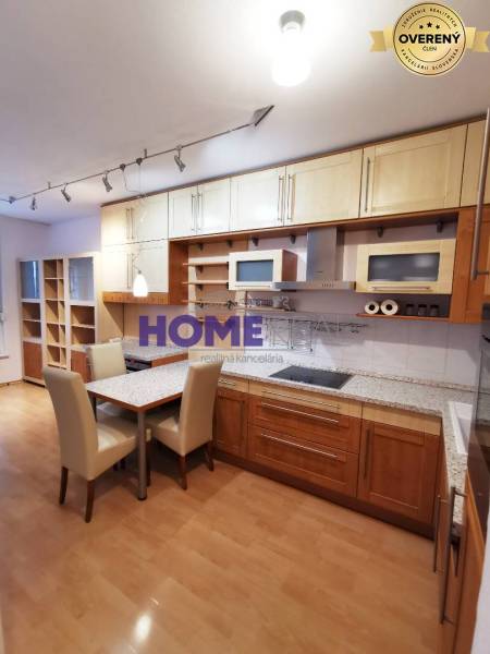 A kitchen unit with a wooden decor and a dining table in a 2-room apartment.