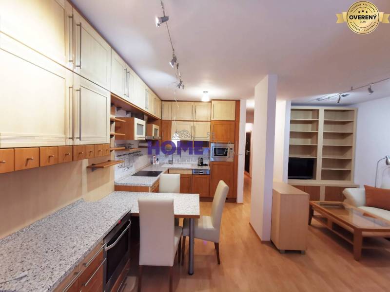 A kitchen unit with a dining table and a wooden decor floor in a 2-room apartment.