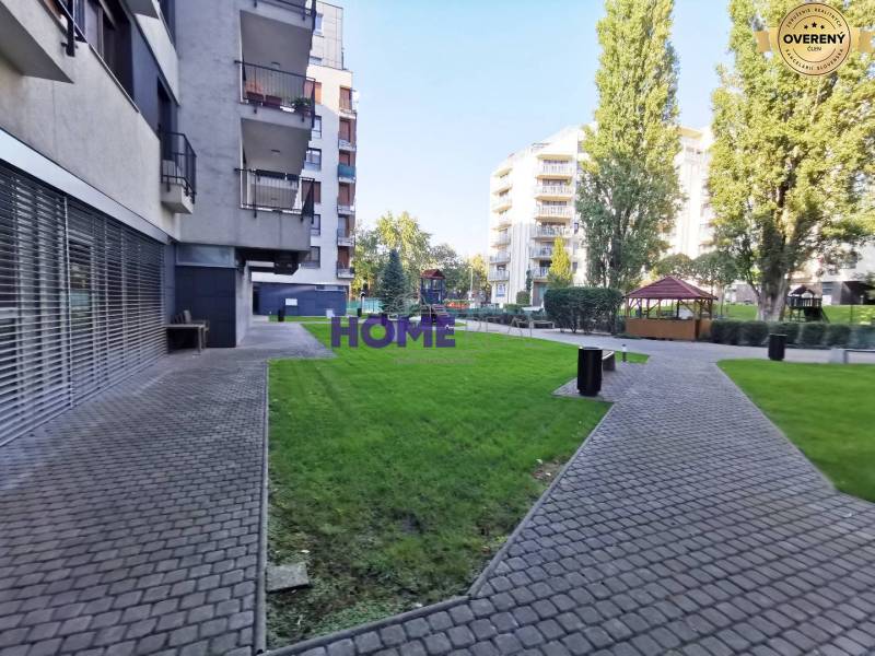 A view of a residential area with a sidewalk and green lawns in Bratislava on Drieňová.
