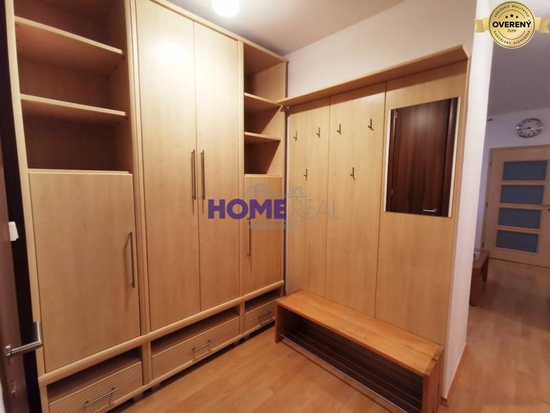 Entrance hall in a 2-room apartment with wooden decor furniture and a mirror.
