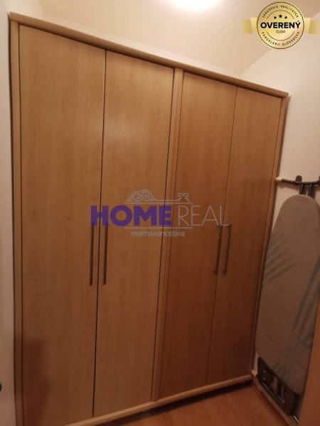 In the 2-room apartment, you can see a wardrobe with a wooden decor and an ironing board.