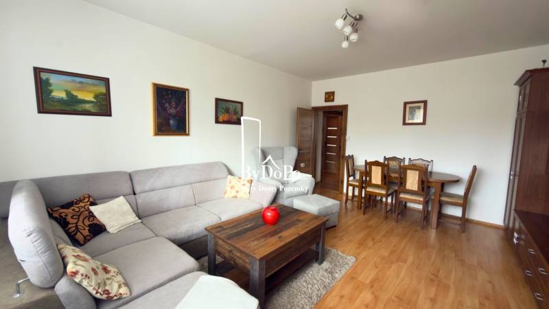 Living room in a 3-room apartment with a corner sofa and a wooden decor floor.