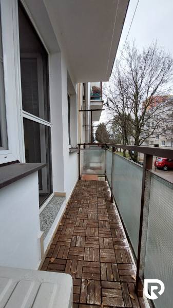 The balcony of a 3-room apartment on Pred poľom Street in Trenčín with a wooden decor floor.