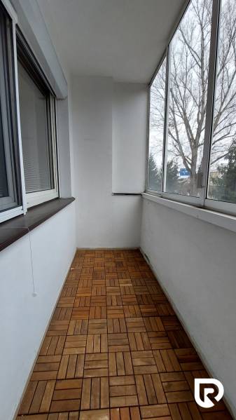 Glazed loggia with wood-decor flooring in a 3-room apartment.