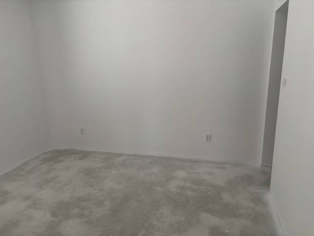 A room with white walls and a plain carpet in a family house.