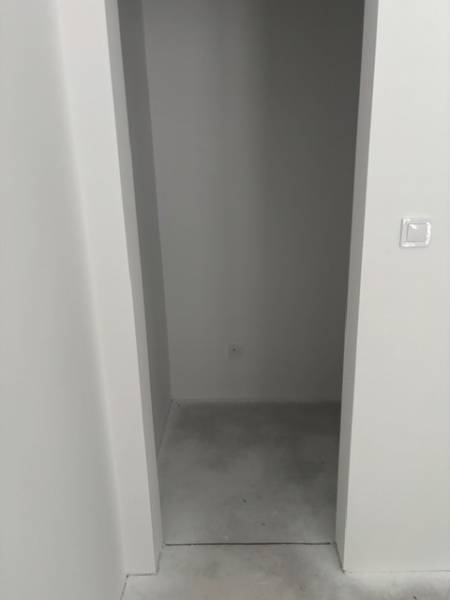 Narrow storage spaces with a concrete floor in a family house.