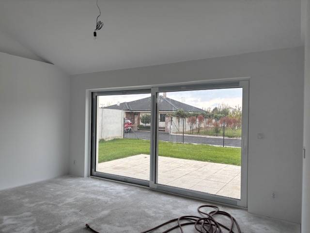 A family house with a glass wall and a view of the garden.