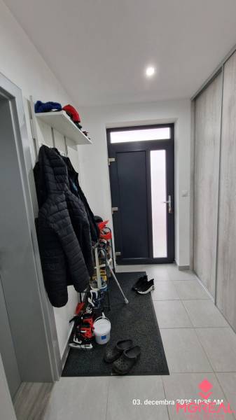 Entrance hall of a family house, with tiles, a coat rack, and a shoe shelf.