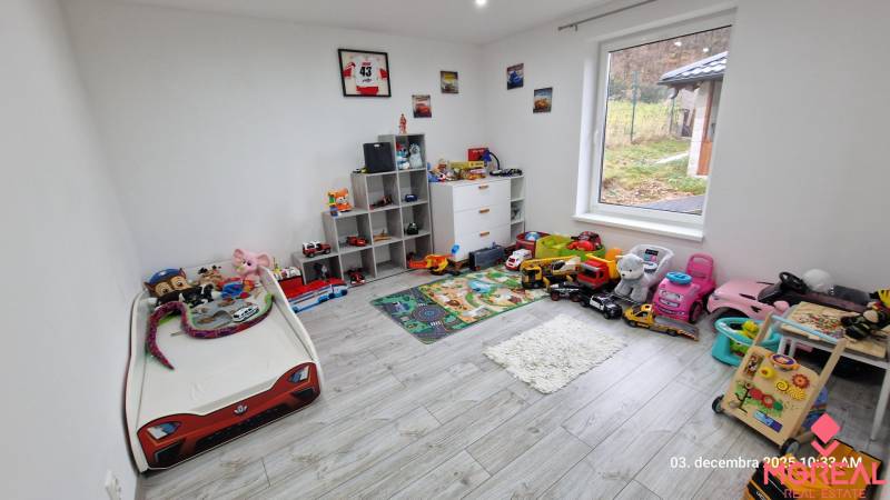 Children's room in a family house with toys, a bed, and a wooden decor floor.