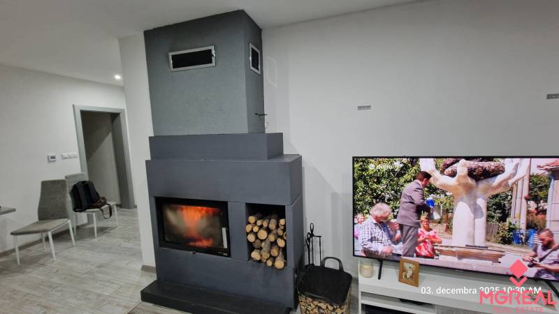 Interior of a family house with a fireplace and a television on a floor with wooden decor.