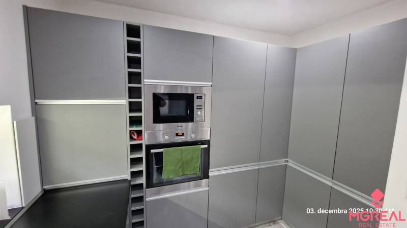 A kitchen in a family house with gray cabinets, a built-in microwave, and an oven.
