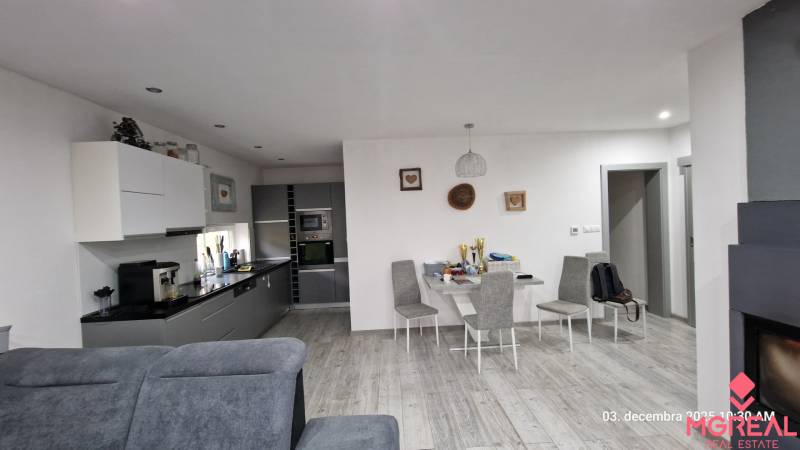 Interior of a family house with a kitchen, dining table, and floor with wooden decor.