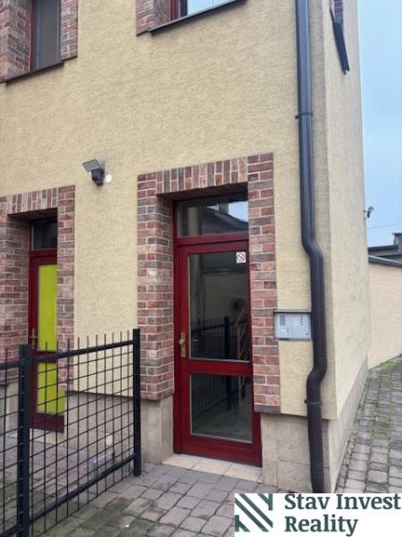 In Senec, you will find offices in a brick building with red doors.