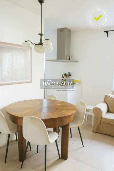 A dining room with a round table in a 3-room apartment, light walls, and a floor with a wooden decor.