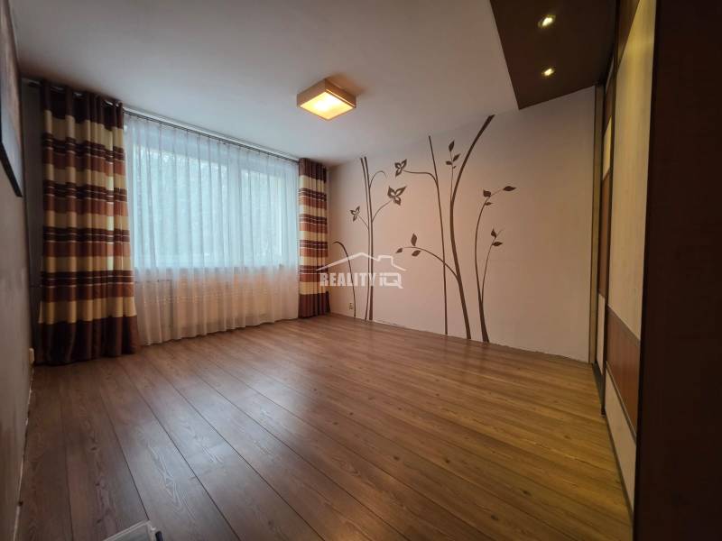 A spacious room with wall decoration, wooden decor flooring, 4-room apartment.