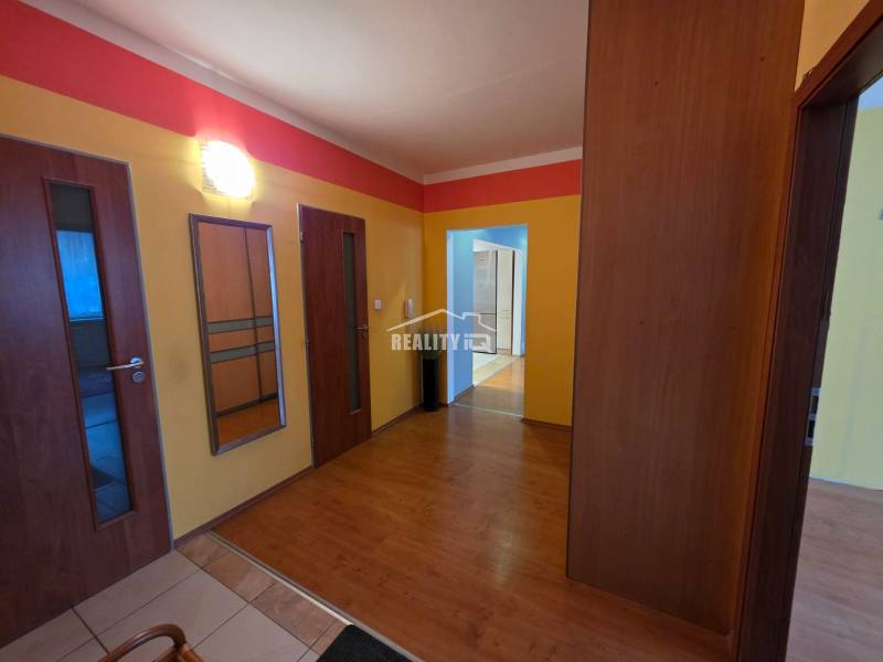 A colorful hallway in a 4-room apartment with a wooden decor floor, built-in wardrobe.