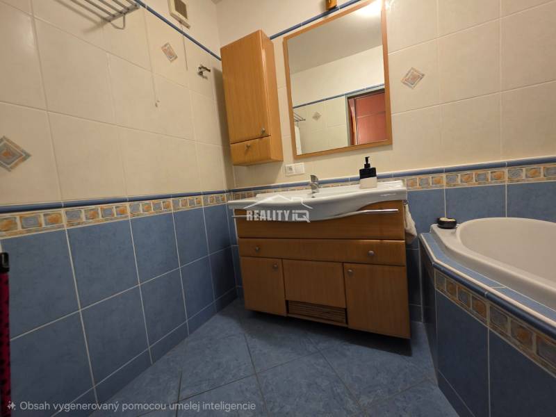 A bathroom in a 4-room apartment with a bathtub, blue tiles, and a cabinet with a sink.
