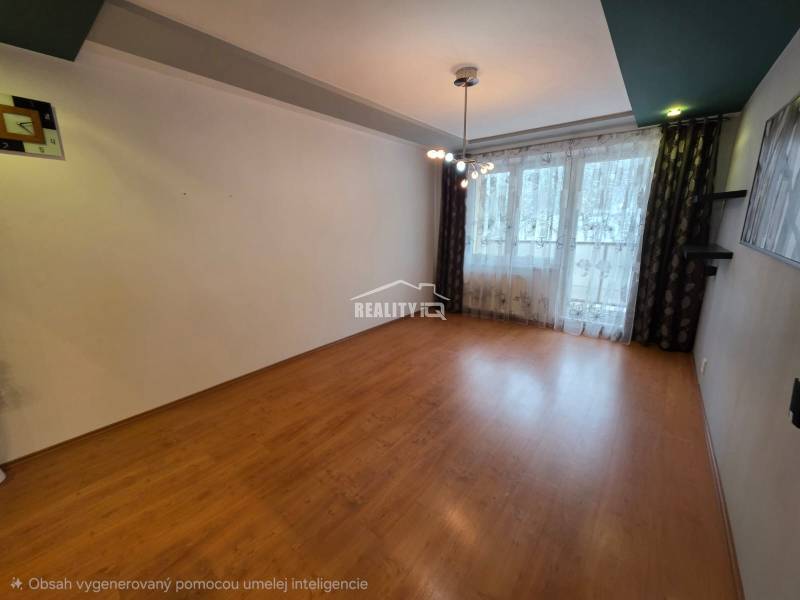 Living room of a 4-room apartment with a wooden decor floor and a large window.