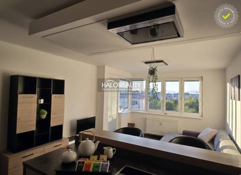 Living room in a two-room apartment with light walls and windows, furnished with furniture.