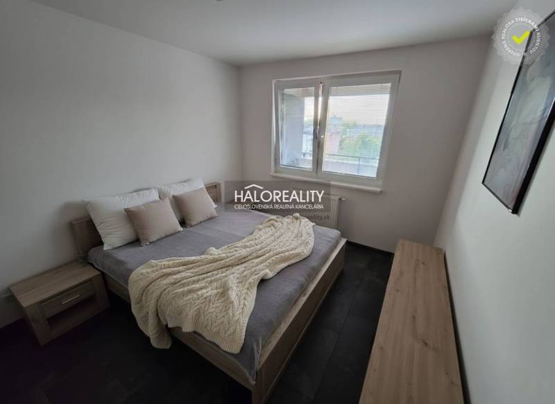 A bedroom in a 2-room apartment with a bed, nightstands, and wall decor.