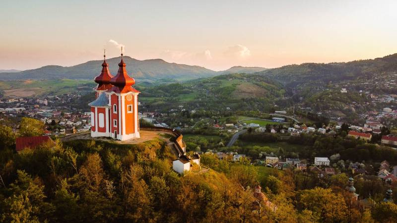 Calvary on the hill with a panorama of Banská Štiavnica, surrounded by agricultural and forest lands.
