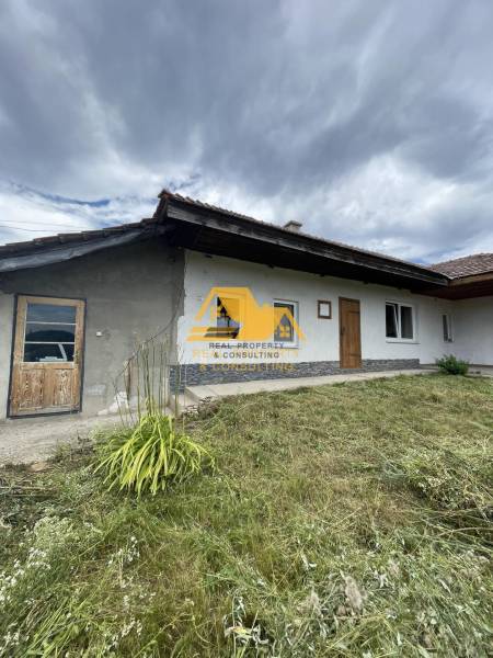 A family house in Svodín on Svodinská Street with a grassy front garden under a cloudy sky.