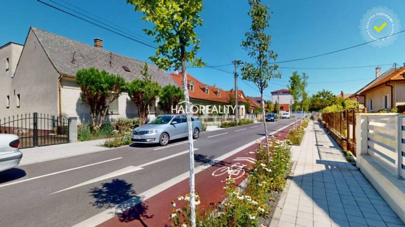 A beautiful street with family houses in Malacky, a cycle path, and well-maintained gardens.