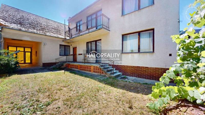 A family house in Malacky with a balcony, stairs, and a garden, accompanied by a shelter.