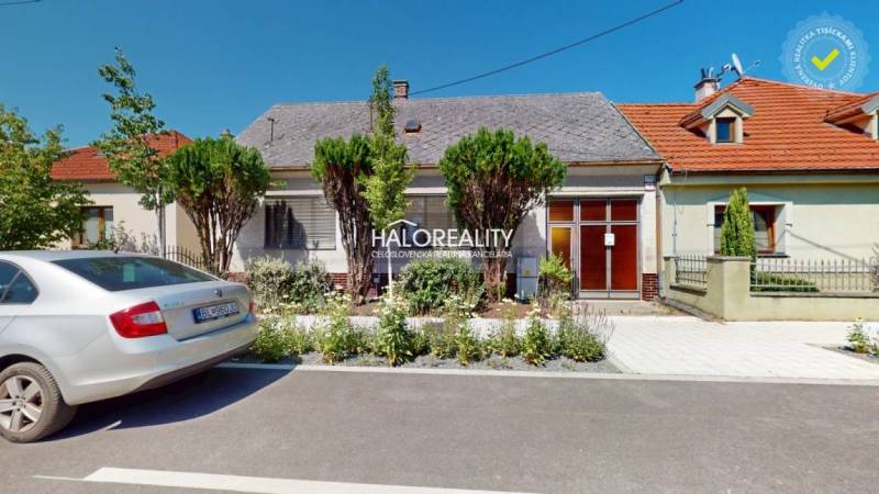A family house in Malacky with a front garden, a parked car, and original architecture.