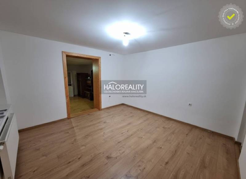 Interior of a family house with a wood-patterned floor and white walls.