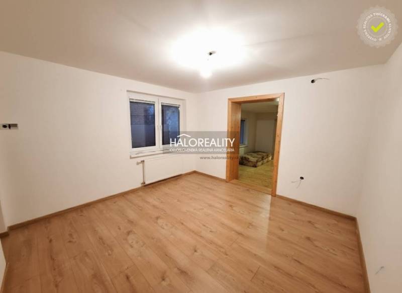 A room in a family house with a wooden decor floor and white walls.