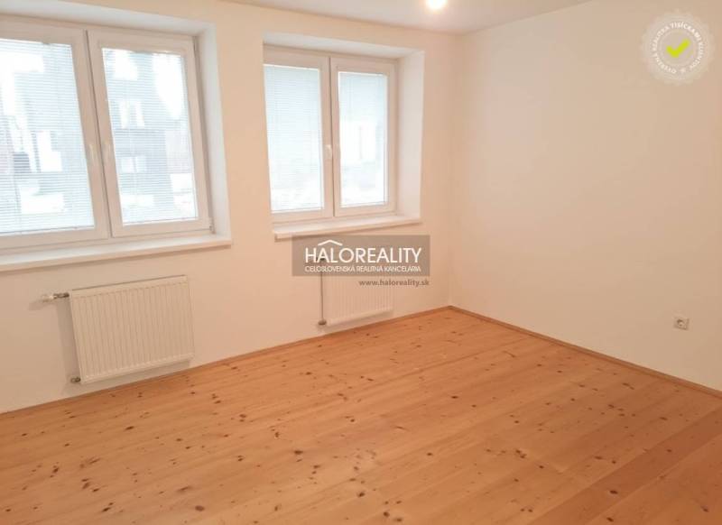 A room in a family house with a wooden decor floor and white walls.