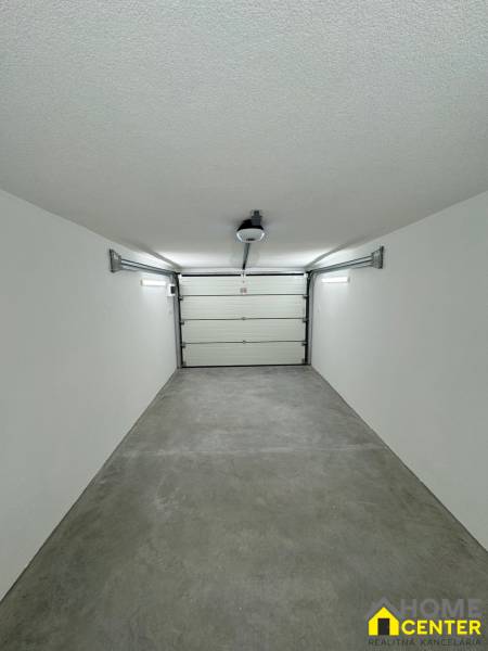 White wall and floor in the Garage space with an automatic door.