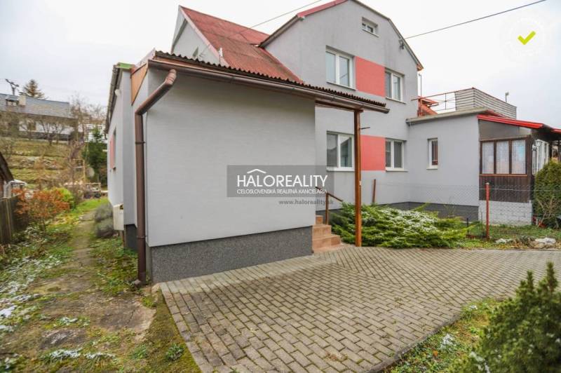 A family house in Brvnište with a red roof and a paved access road.