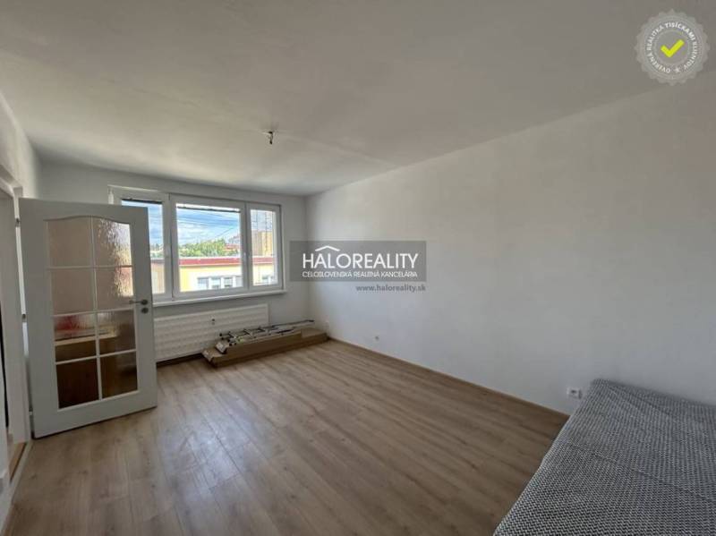 A bright room with a wood-patterned floor in a studio apartment.