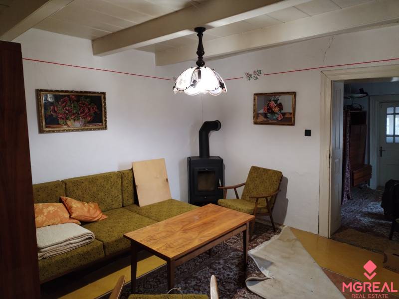Living room of a family house with a stove, antique furniture, and decorations.