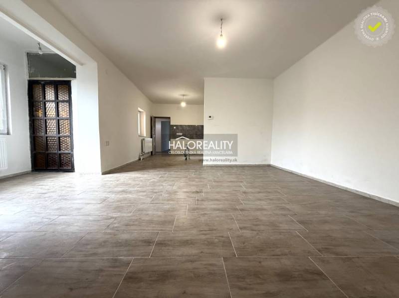 A spacious interior with large windows and wood-patterned flooring in a family house.
