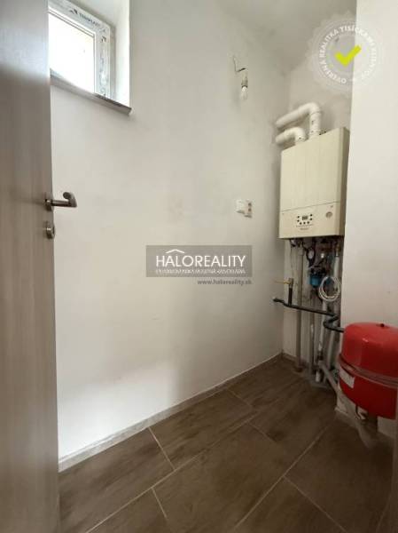 Technical room in a family house with a boiler and a floor with a wooden decor.