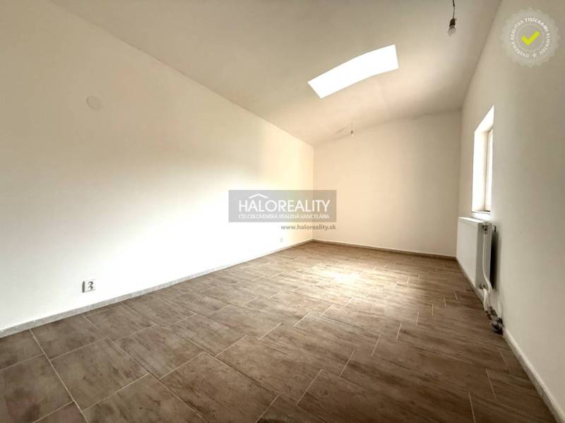 A spacious room with a wood-patterned floor in a family house.