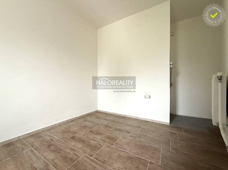 An empty room with a wood-patterned floor in a family house.