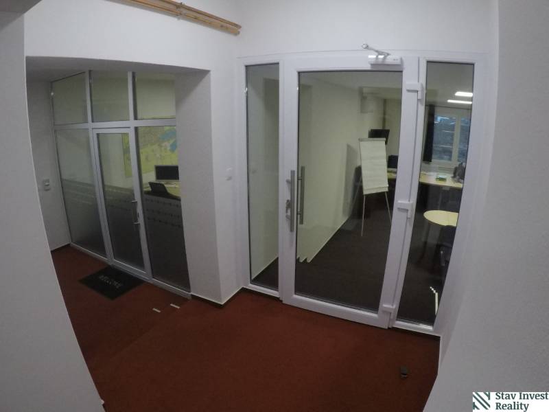 Glass doors and glass-walled offices with red carpet in the offices.