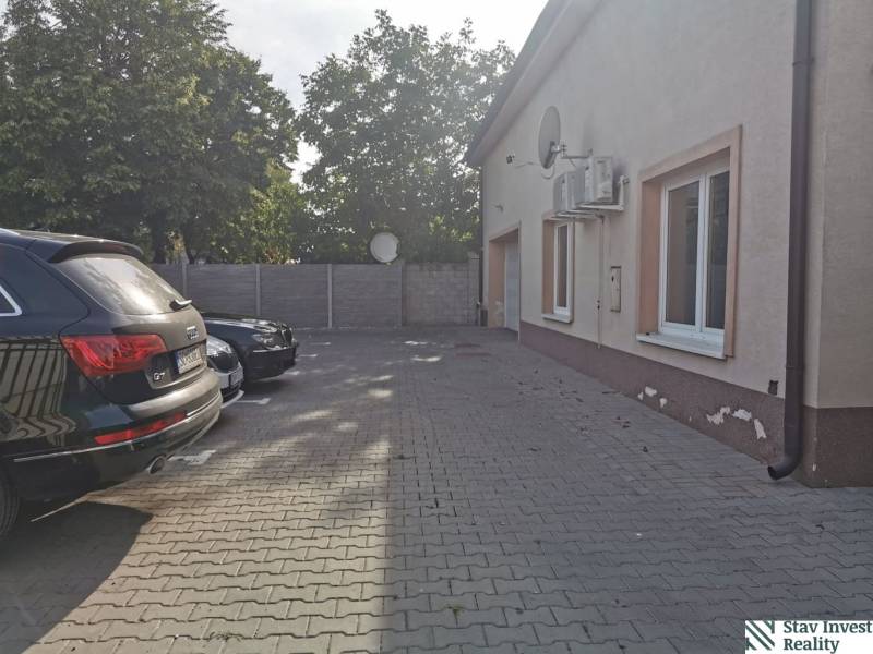 Parking lot near the offices on Šamorínska Street in Senec with cars and trees in the background.