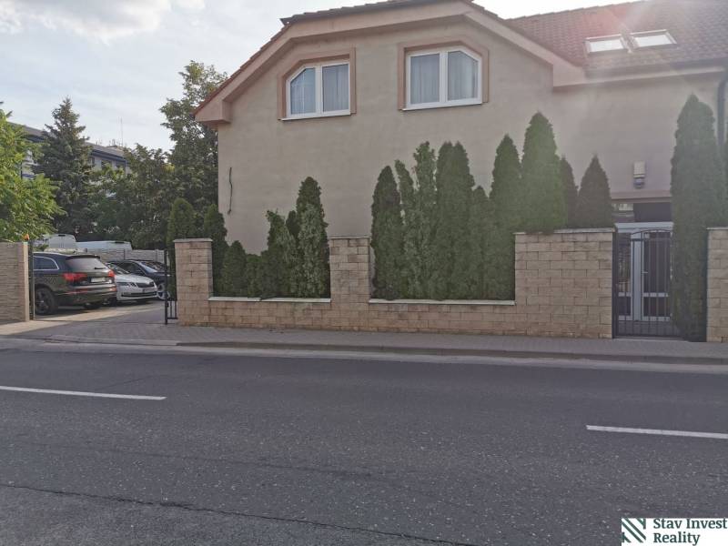 Office building on Šamorínska Street in Senec, with parking and coniferous trees.