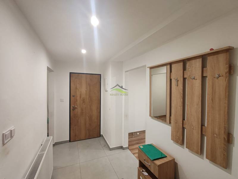 A hallway in a 3-room apartment with a wardrobe wall and ceramic flooring.