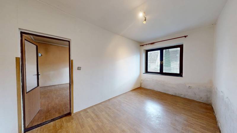 A room with a wooden floor decor, a window, and a door in a family house.