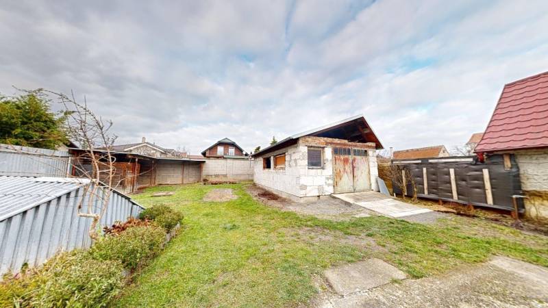 Garden with lawn and garage at a family house on SNP Street, Veľké Leváre.