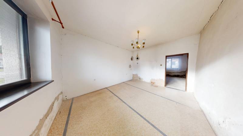 A room in a family house with white walls, simple windows, and light.